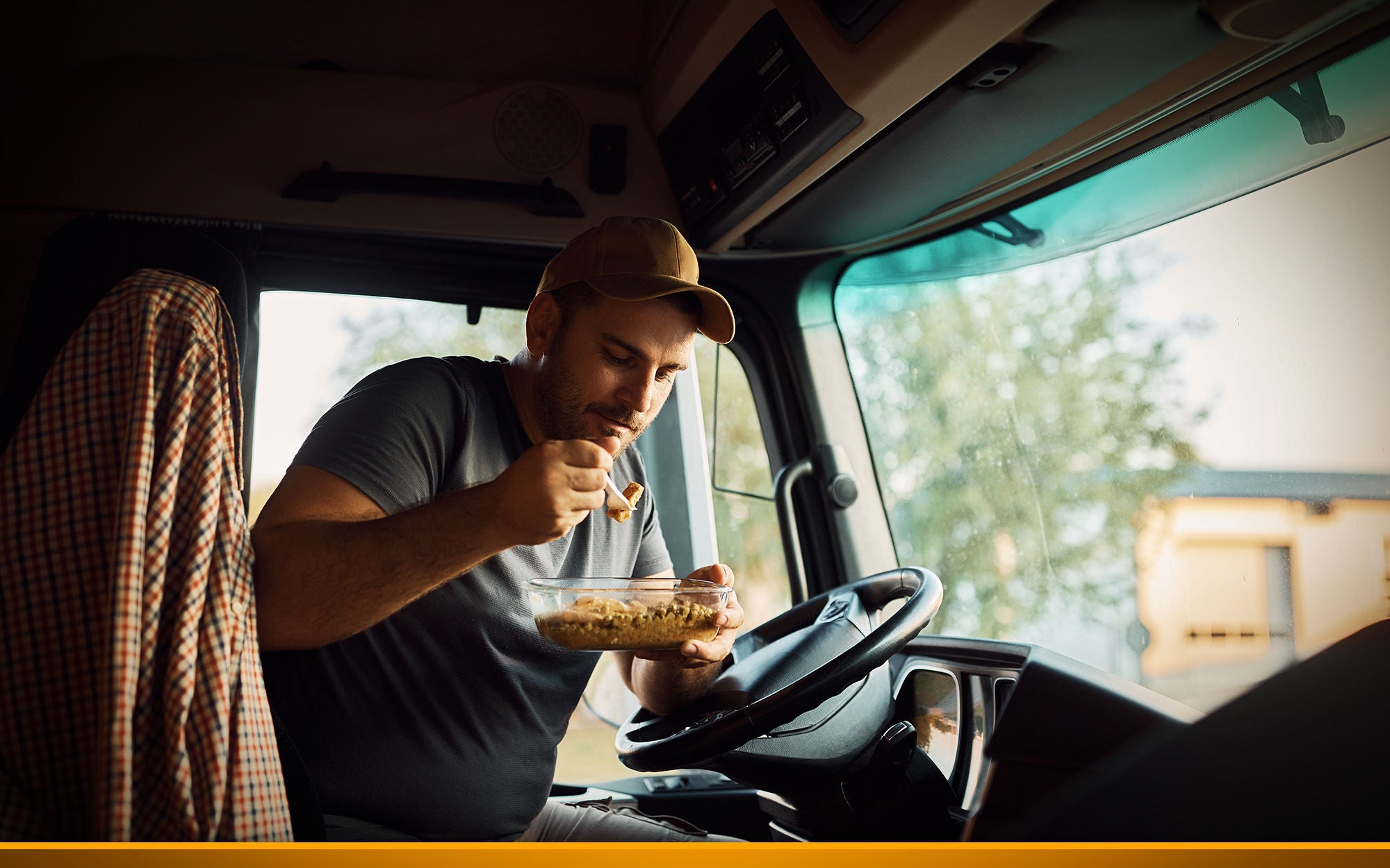 truck driver eating lunch inside of his truck